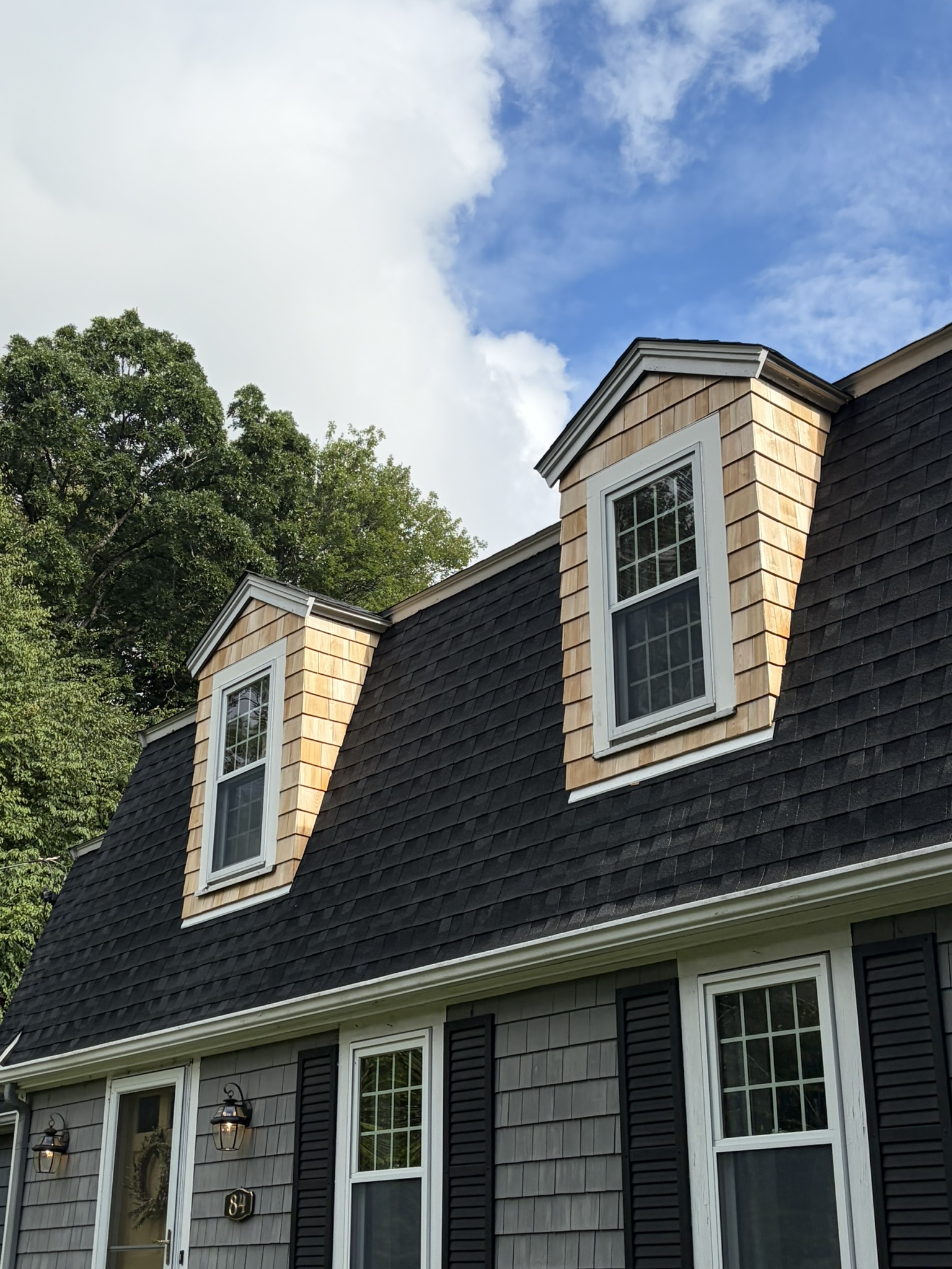 Home exterior with new roof and dormers by Red Sky Construction
